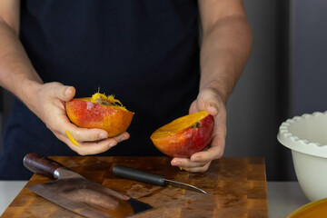 Chef cook cutting fresh mango for fruit salad on wooden cut board