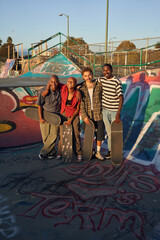 Portrait of four young skateboarders at the skatepark 
