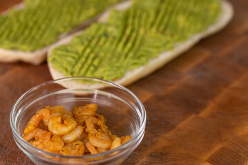 Chef cook hands making fresh diet avocado toast with seafood shrimps. Healthy vitamin breakfast.
