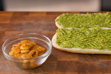 Chef cook hands making fresh diet avocado toast with seafood shrimps. Healthy vitamin breakfast.