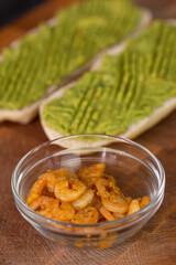 Chef cook hands making fresh diet avocado toast with seafood shrimps. Healthy vitamin breakfast.