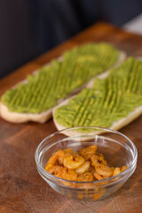 Chef cook hands making fresh diet avocado toast with seafood shrimps. Healthy vitamin breakfast.