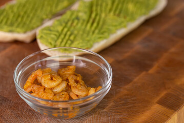 Chef cook hands making fresh diet avocado toast with seafood shrimps. Healthy vitamin breakfast.