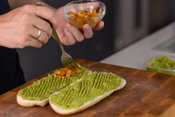 Chef cook hands making fresh diet avocado toast with seafood shrimps. Healthy vitamin breakfast.