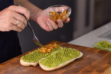 Chef cook hands making fresh diet avocado toast with seafood shrimps. Healthy vitamin breakfast.
