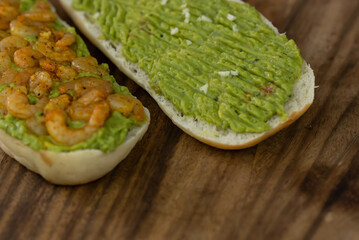 Close up of fresh diet avocado toast with seafood shrimps. Healthy vitamin breakfast.
