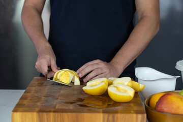 Chef cook cutting fresh apples for fruit salad on wooden cut board