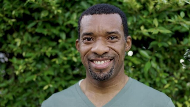 Portrait of attractive positive black African man. Close up portrait of afro man, Happy handsome nerd American guy in casual cloth with big smile stand in the nature park.