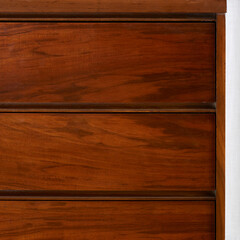 Front detail of vintage walnut, mid-century modern dresser. Wood grain texture.