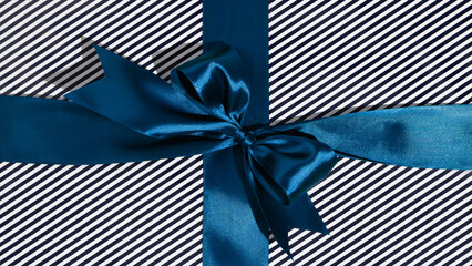 Blue gift ribbon and bow on black and white wrapping paper