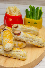 Halloween food with scary faces in bell peppers and with fingers with sausage and cheese
