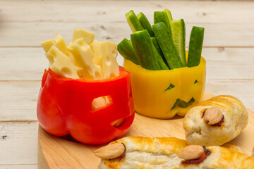 Halloween food with scary faces in bell peppers and with fingers with sausage and cheese