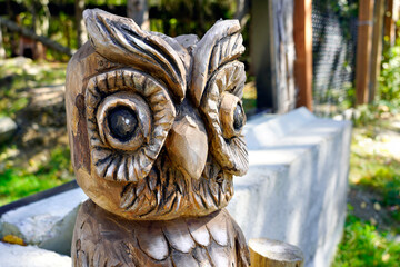 A picture of a wooden sculpture of an owl totem