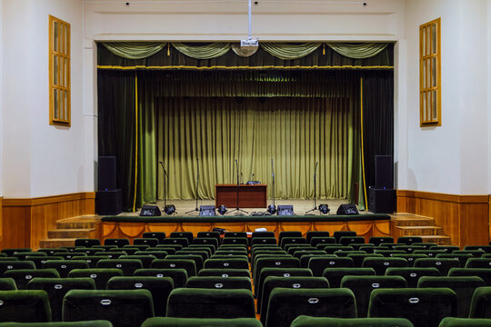 Assembly hall with stage for performance and rows of empty chairs