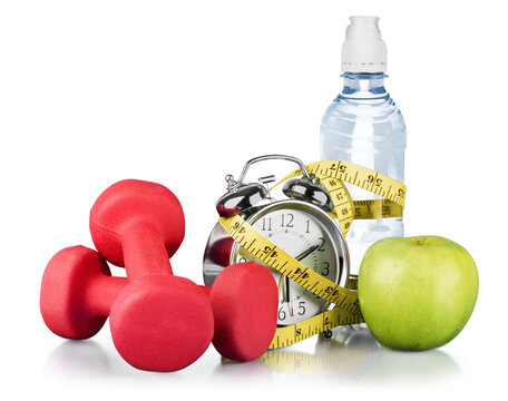 Green alarm clock, apple, bottle of water,  measuring tape and dumbbells as concept of diet - isolated on white