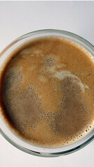 top view on a cup of coffee as mobile wallpaper background, vertical mobile phone wallpaper, directly above shot of a coffee glass with milk on white background
