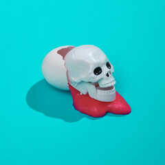 Creative layout with scary skull and slime, eggshell on bright blue background. Visual trend. Halloween concept. Minimalistic aesthetic still life with shadow. Fresh idea