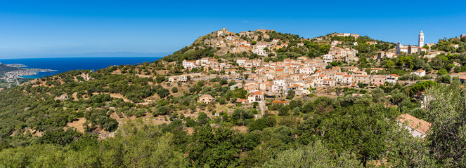 View of Corbara village with stone houses built in traditional Corsican style on top of a hill, Corsica, France