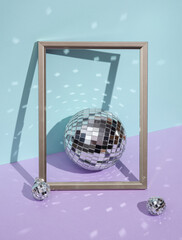 Creative minimal still life with mirrored disco balls and frame on pastel background. Party concept. visual trend. Retro aesthetic