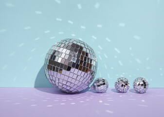Creative minimal still life with mirrored disco balls on pastel background. Party concept. visual trend. Retro aesthetic