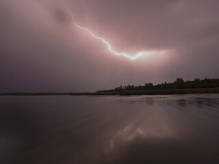 The blue lightning is real. Thunderstorm at night on the lake.