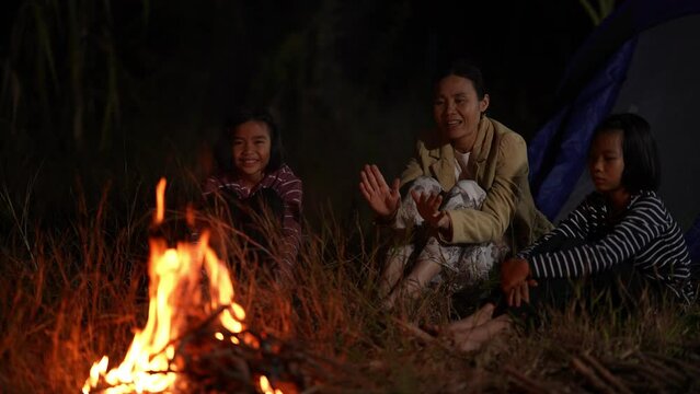Family people on fire camp in night background 