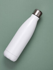 White metal thermal bottle for water on green background. Stainless Steel Vacuum Insulated thermos Bottle