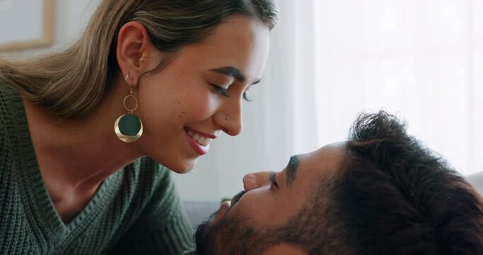 Couple, kiss or bonding on sofa in house living room or relax home in love, trust or security. Smile, happy and bonding interracial man or woman in intimate, romantic or support union on lounge couch