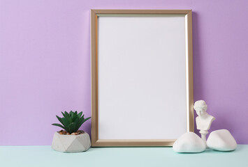 Photo frame with a white sheet of paper (mockup) and decor on a pastel background. Minimal still life