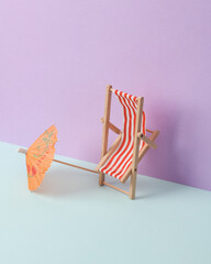 Creative summer layout with deck chair and cocktail umbrella on pastel background. Conceptual pop. Minimal still life