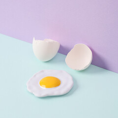 Creative layout. Scrambled eggs with eggshell on two tone pastel background. Conceptual pop. Minimal food still life.