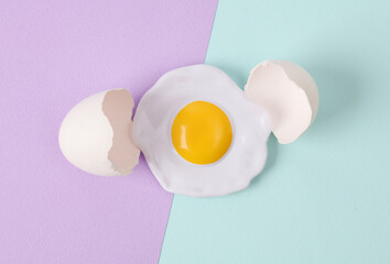 Creative layout. Scrambled eggs with eggshell on two tone pastel background. Conceptual pop. Minimal food still life.