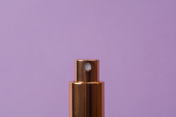 Close-up shot of perfume bottle sprayer on magenta background