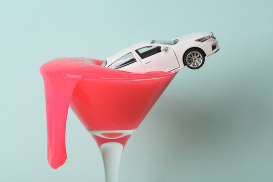Creative layout, cocktail glass with neon slime and car on pastel background. Visual trend. Minimalistic aesthetic still life.