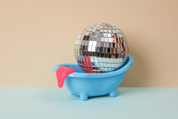 Creative still life, toy bathroom sink with disco ball and neon slime on two tone pastel background. Visual trend.
