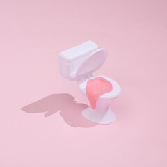 Creative layout, toilet with slime on bright pink background with shadow. Visual trend. Fresh idea. Concept pop