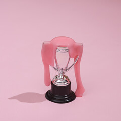 Creative layout, winner cup with slime on pink background with shadow. Visual trend. Fresh idea. Concept pop