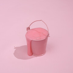 Creative summer layout, bucket with slime on pink background with shadow. Visual trend. Fresh idea. Concept pop