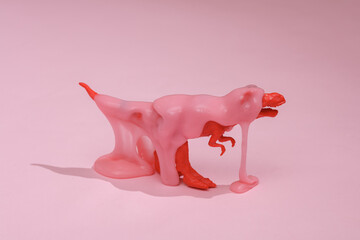 Creative layout, toy tyrannosaurus with slime on pink background with shadow. Visual trend. Fresh idea. Concept pop