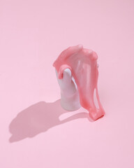 Creative layout, Plastic hand with slime on pink background with shadow. Visual trend. Fresh idea. Concept pop