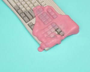 Creative retro layout, Old keyboard with slime on blue pastel background. Visual trend. Fresh idea