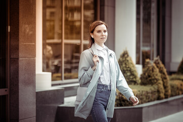 Cute woman comes out of the building. Lifestyle