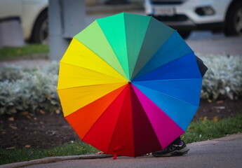 Umbrella in the colors of the rainbow (LGBT) on the street during the day