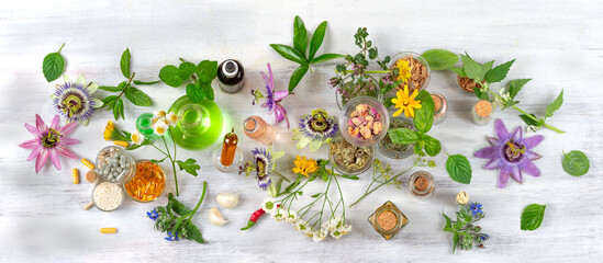 Passionflowers around bottles of vegetable oil, cosmetics, capsules, food supplements-Top view