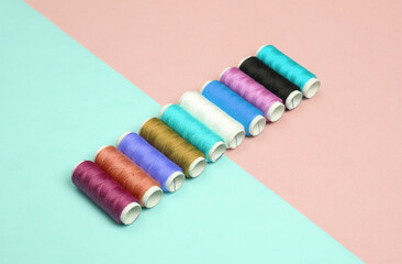 Skeins of colored thread on a blue-pink pastel background