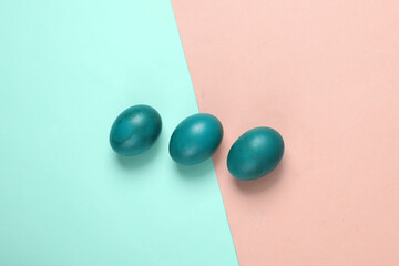 Painted red Easter eggs on a blue-pink pastel background. Easter minimalistic composition. Top view