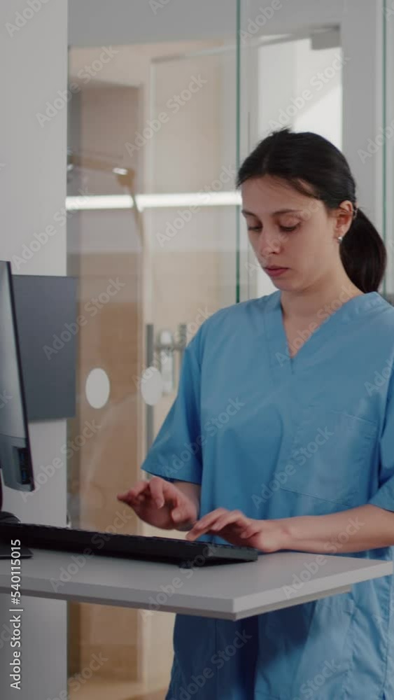 Poster vertical video: front view of assistant typing medical expertise on computer while in background afr