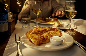 Chebureki with lamb fried in a frying pan and greased with butter with sour cream on a white...