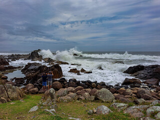 waves crashing against the rocks on the beach in Florianópolis