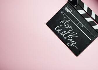 story telling textr on clapper borad against pink background
